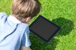 Young Boy Using Digital Tablet Outdoors Stock Photo