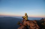 Thai Woman Sitting On Cliff Rock Enjoy Mountains View Stock Photo