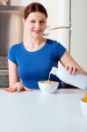 Woman Pouring Milk Into Cereal Stock Photo