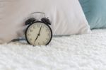 Modern Black Alarm Clock On Bed Stock Photo