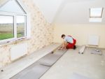 Handyman Laying Down Laminate Flooring Boards Stock Photo