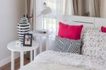 Red Pillows On Wooden White Bed With Modern Lamp Stock Photo