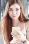 Portrait Of Thai Adult Beautiful Girl Using Her Smart Phone And Smile Stock Photo