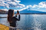 Woman Use Mobile Phone Take A Photo At Fuji Mountains, Kawaguchiko Lake In Japan Stock Photo