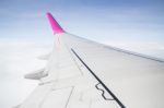 Airplane Wing Flying Above The Clouds Stock Photo