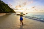 Happy Girl On The Beach At Sunrise Stock Photo