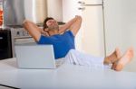 Man In Kitchen With Laptop Stock Photo