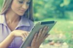 Beautiful Woman With Tablet Computer In Park Stock Photo