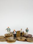 Miniature Businessman Stand On Euro Coins And Book Bank. Busines Stock Photo