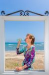 Drinking Woman In Window At Sea Stock Photo