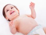 Playful Baby Lying With Has Hands Up Stock Photo