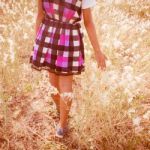 Girl Walking In Grass Field Stock Photo