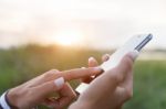 Hand Using Phone Outdoor At Sunset Stock Photo