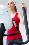 Happy Young Woman  With Elliptic Machine In The Gym Stock Photo