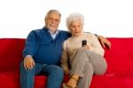 Elderly Couple With Remote Control Stock Photo