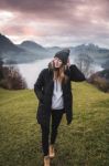 Woman On A Meadow At Sunset Over The Lake Stock Photo