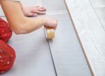 Handyman's Hands Laying Down Laminate Flooring Boards Stock Photo