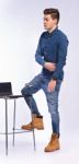 Male Model In Denim Jeans Sitting On A Chair . Studio Shoot Stock Photo