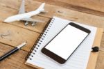 Phone Blank Screen And Airplane Model On Wood Table Stock Photo