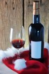 Wine Glass And Bottle With Red Santa Hat On Wooden Background Stock Photo