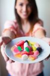 Cute Young Woman Eating Jelly Candies With A Fresh Smile Stock Photo