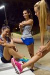 Group Of Girls Doing Stretching At Night Stock Photo