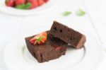 Chocolate Brownie Cake On White Plate Decorated With Strawberrie Stock Photo