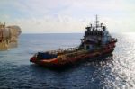 Supply Boat Transfer Cargo To Oil And Gas Industry And Moving Cargo From The Boat To The Platform Stock Photo