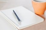 Pen And Spiral Notebook With Coffee Cup Stock Photo