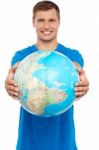 Casual Young Guy Presenting Globe Stock Photo