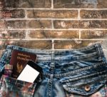 Blue Jeans With Cell Phone, Flashlight And Passport In A Pocket Stock Photo