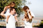 Parents Holding Children On Shoulder Stock Photo