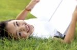 Asian Little Girl Relax And Reading A Book In The Park Stock Photo