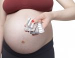 Pregnant Woman Holding Pills Stock Photo