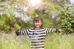 Lovely Kid Smiling Face With Happiness Emotion In Natural Green Field Stock Photo