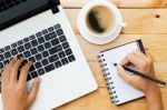 Hand Using Laptop And Write Note Inspire Idea On Wood Desk Stock Photo