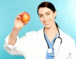 Female Doctor Showing An Apple Stock Photo