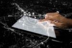 Double Exposure Hand Using Tablet And City On Night Background Stock Photo