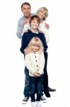 Affectionate Family Of Four Standing In A Row Stock Photo