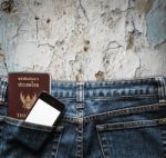 Blue Jeans With Cell Phone And Passport In A Pocket Background Stock Photo