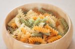 Raw Fusilli Pasta On Wooden Bowl Stock Photo