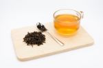 Clear Glass Of Tea And Dry Tea Leaves On Wooden Plate Isolated O Stock Photo