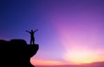 Silhouette Of A Man On The Rock At Sunset Stock Photo