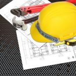 Yellow Helmet Of Labor Constructor With Blueprints Building Stock Photo