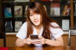 Portrait Of Thai Adult Student University Uniform Beautiful Girl Using Her Smart Phone Stock Photo