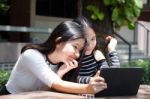 Two Asia Thai High School Student Best Friends Beautiful Girl Using Her Tablet And Funny Stock Photo