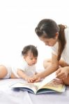 Mother Is Reading A Book For Her Baby Stock Photo