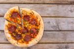 Delicious Baked Salami Pizza Served On Rustic Wooden Table Stock Photo