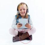 Beautiful Child Listening To Music With Digital Tablet Stock Photo