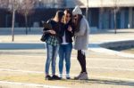 Three Students Girls Using Mobile Phone In The Campus Stock Photo